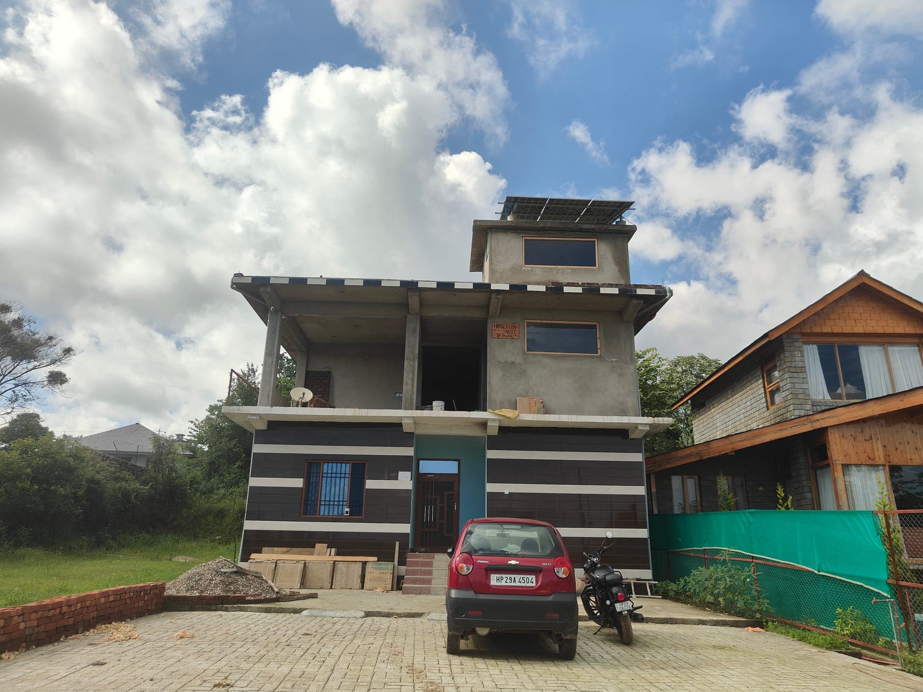 The Himalayan Nest building front, framed by mountains and blue sky.