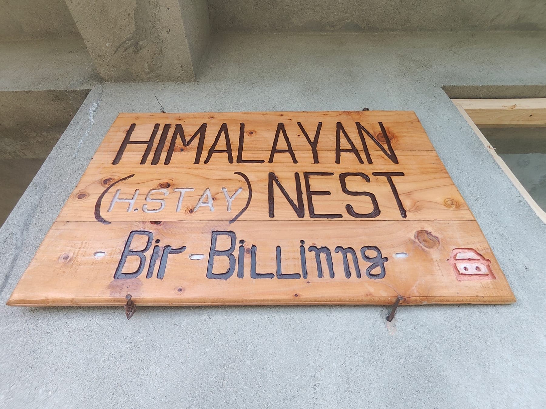The handmade Himalayan Nest nameplate at the entrance.